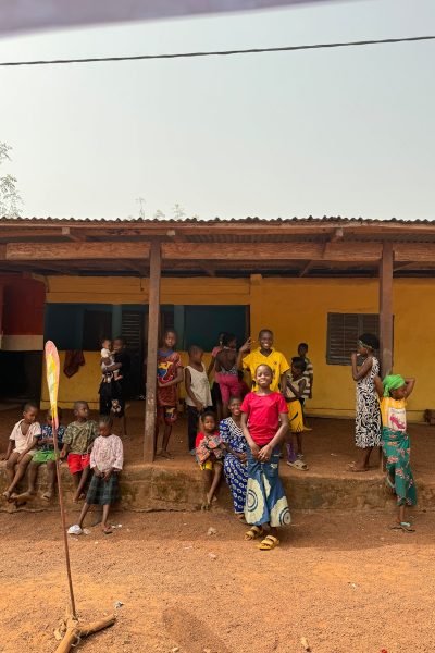 A group of people standing in front of a yellow building